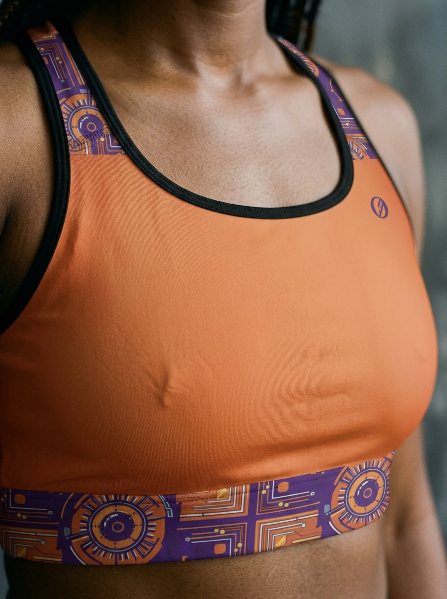 Close-up of the Sango Orange Kinetic Engine print and seam detail on the Sankofa Padded Sports Bra — SunBorn