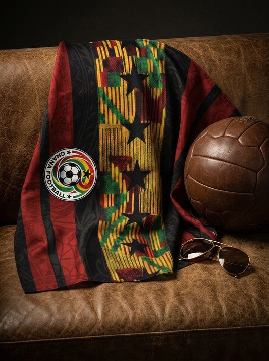 Colorful patterned blanket with a soccer ball logo on a brown leather couch next to a vintage soccer ball.