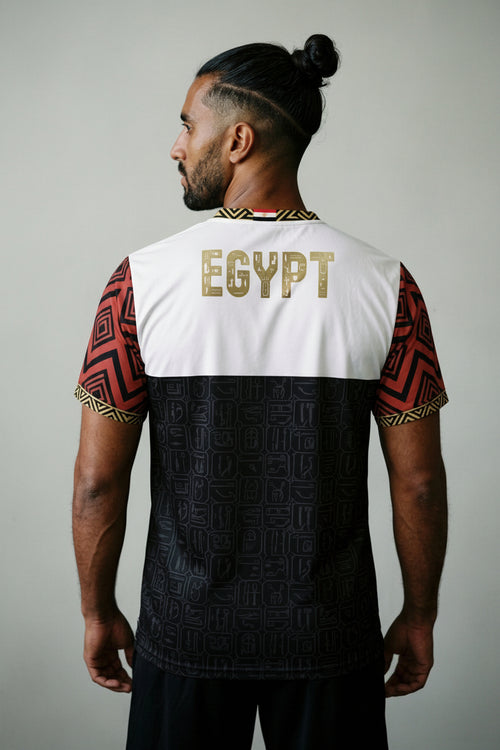 Person wearing a sports jersey with 'Egypt' printed on the back against a dark background