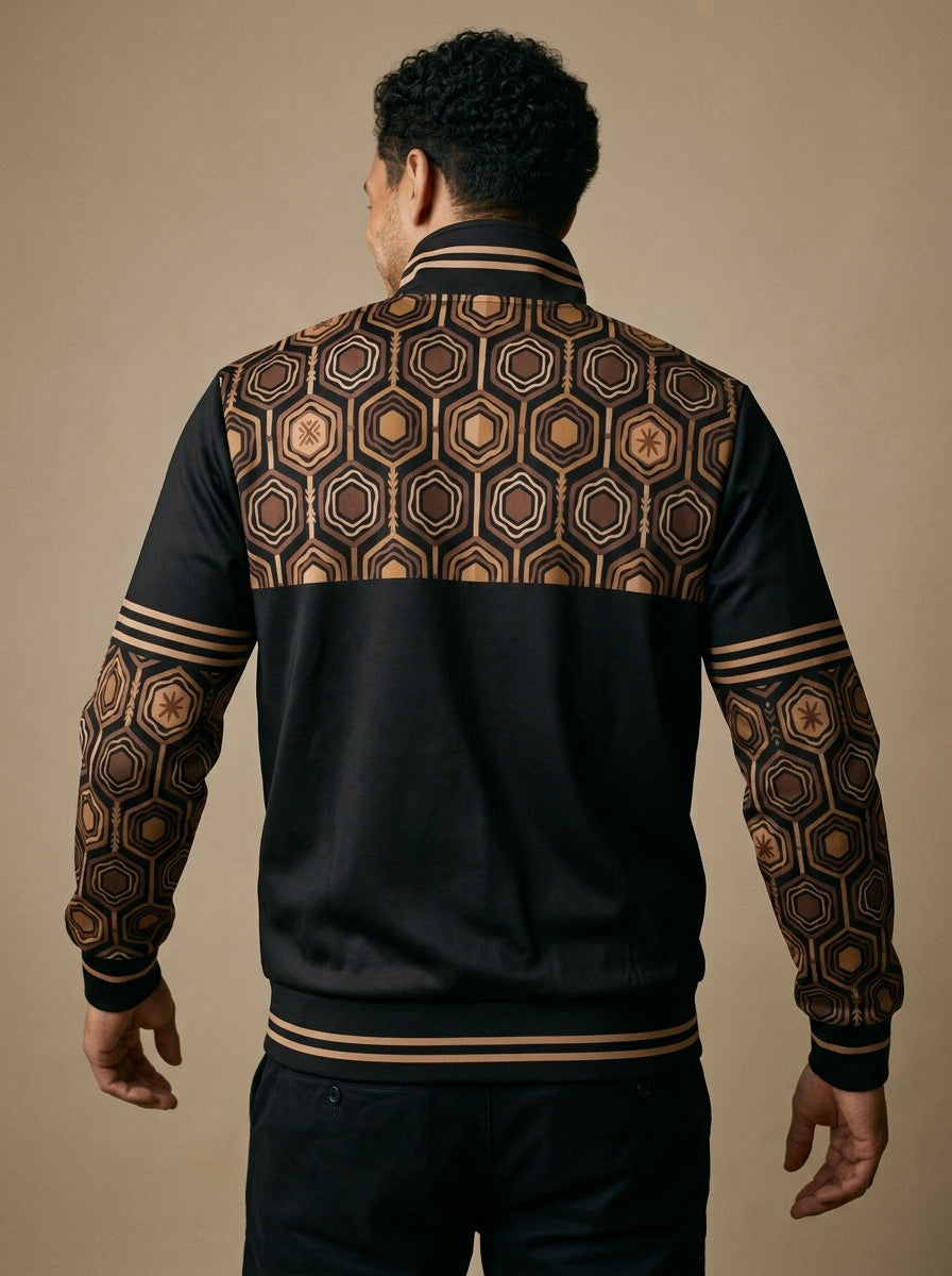 AnanseNova™ Statement Track Jacket in Oji Black — back view on model, hexagon print across the upper back and shoulders with striped cuffs and hem