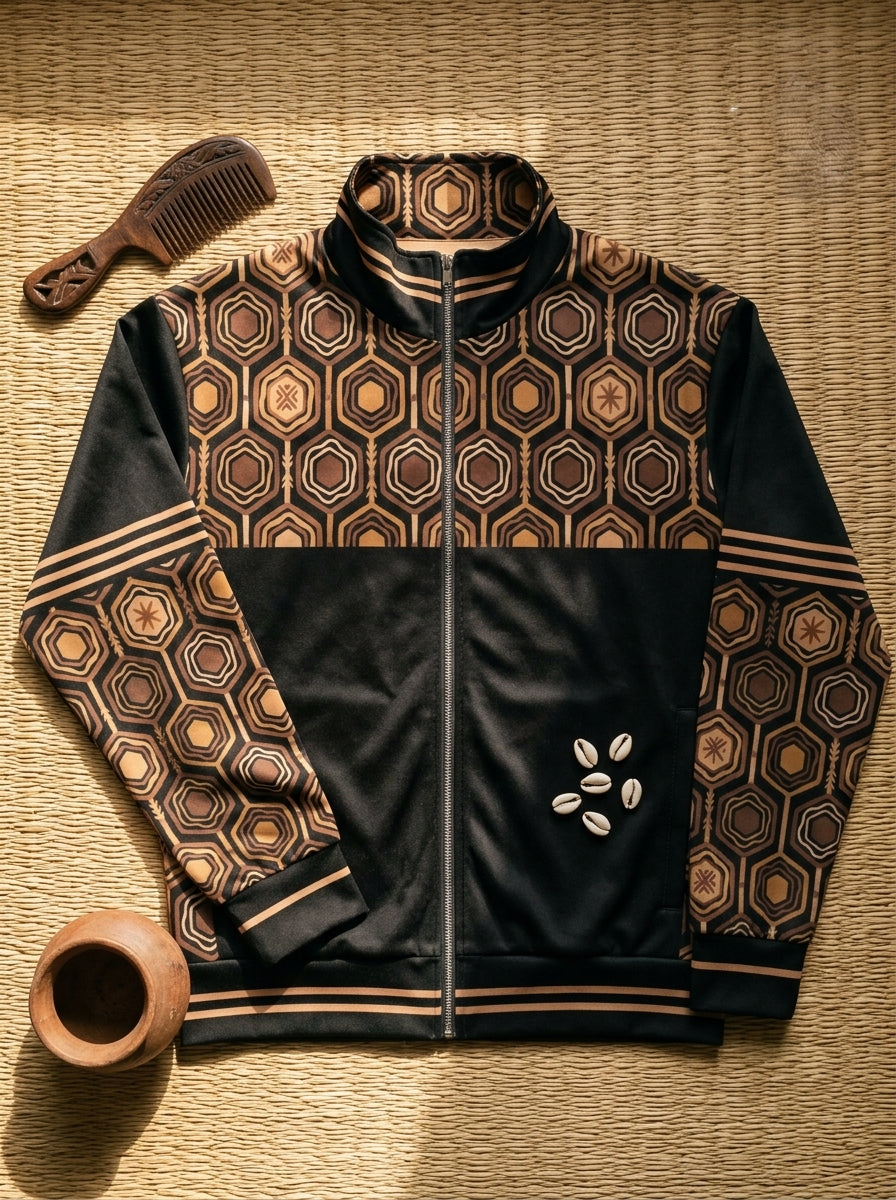 AnanseNova™ Statement Track Jacket in Oji Black — styled flat lay of the full-zip track jacket with hexagon print, laid on woven textiles
