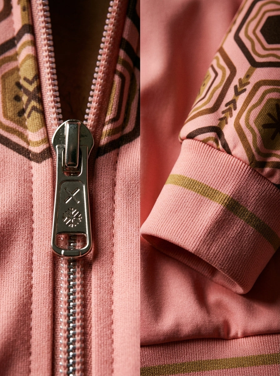 AnanseNova™ Statement Track Jacket in Eze Pink — close-up of the zipper pull, hexagon print and triple-stripe rib cuff on AkomaDrive™ brushed fleece