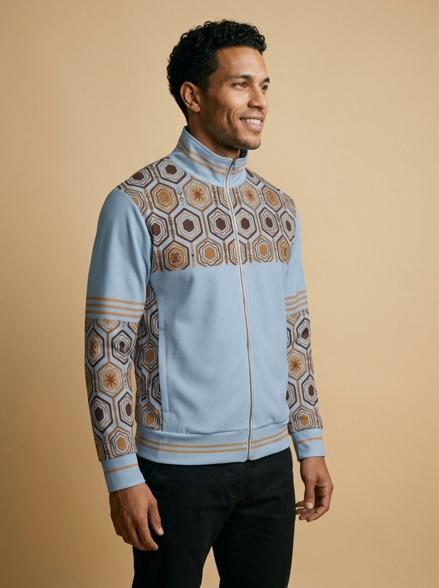 AnanseNova™ Statement Track Jacket in Igwe Blue — three-quarter right view on model, full-zip track jacket with hexagon yoke and forearm panels