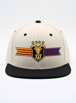 GOAT Catalan two-tone snapback in Ocha White / Oji Black, front view — the full-colour Catalan crest on the crown: gold goat, No. 10, four stars, split Senyera and blaugrana banner.