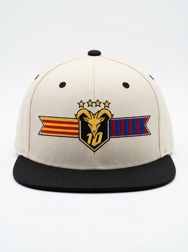 GOAT Catalan two-tone snapback in Ocha White / Oji Black, front view — the full-colour Catalan crest on the crown: gold goat, No. 10, four stars, split Senyera and blaugrana banner.