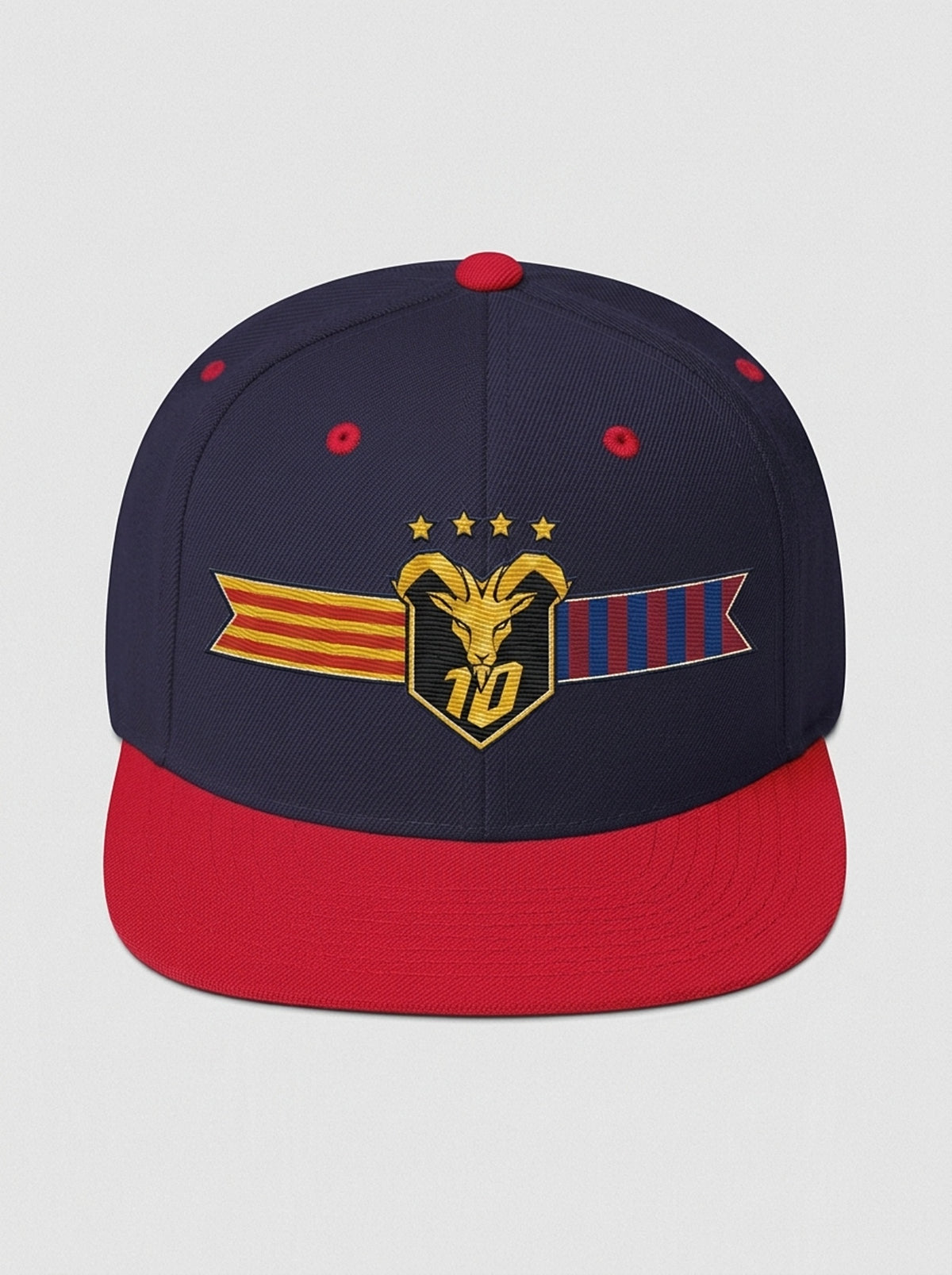 GOAT Catalan two-tone snapback in Anụnụ Blue / Uhie Red, front view — the full-colour Catalan crest on the crown: gold goat, No. 10, four stars, split Senyera and blaugrana banner.