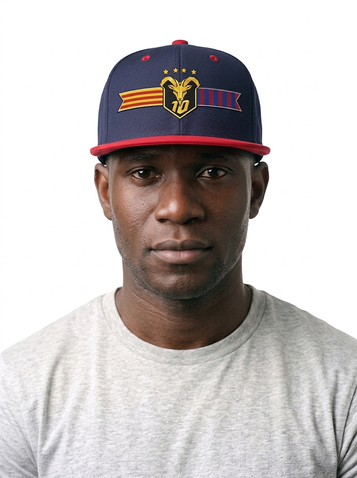 Model wearing the GOAT Catalan two-tone snapback in Anụnụ Blue / Uhie Red, showing the embroidered Catalan crest on the flat-brim cap.