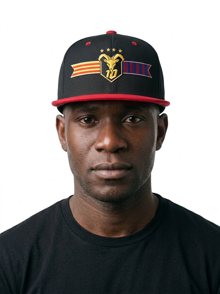 Model wearing the GOAT Catalan two-tone snapback in Oji Black / Uhie Red, showing the embroidered Catalan crest on the flat-brim cap.
