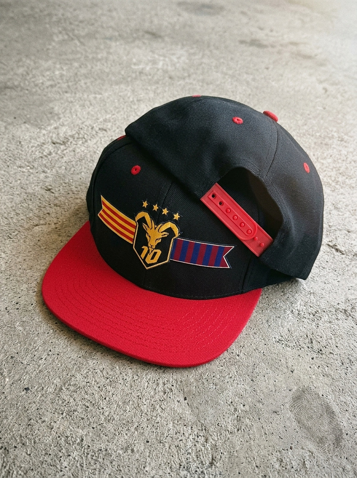 GOAT Catalan two-tone snapback in Oji Black / Uhie Red, styled flat-lay.