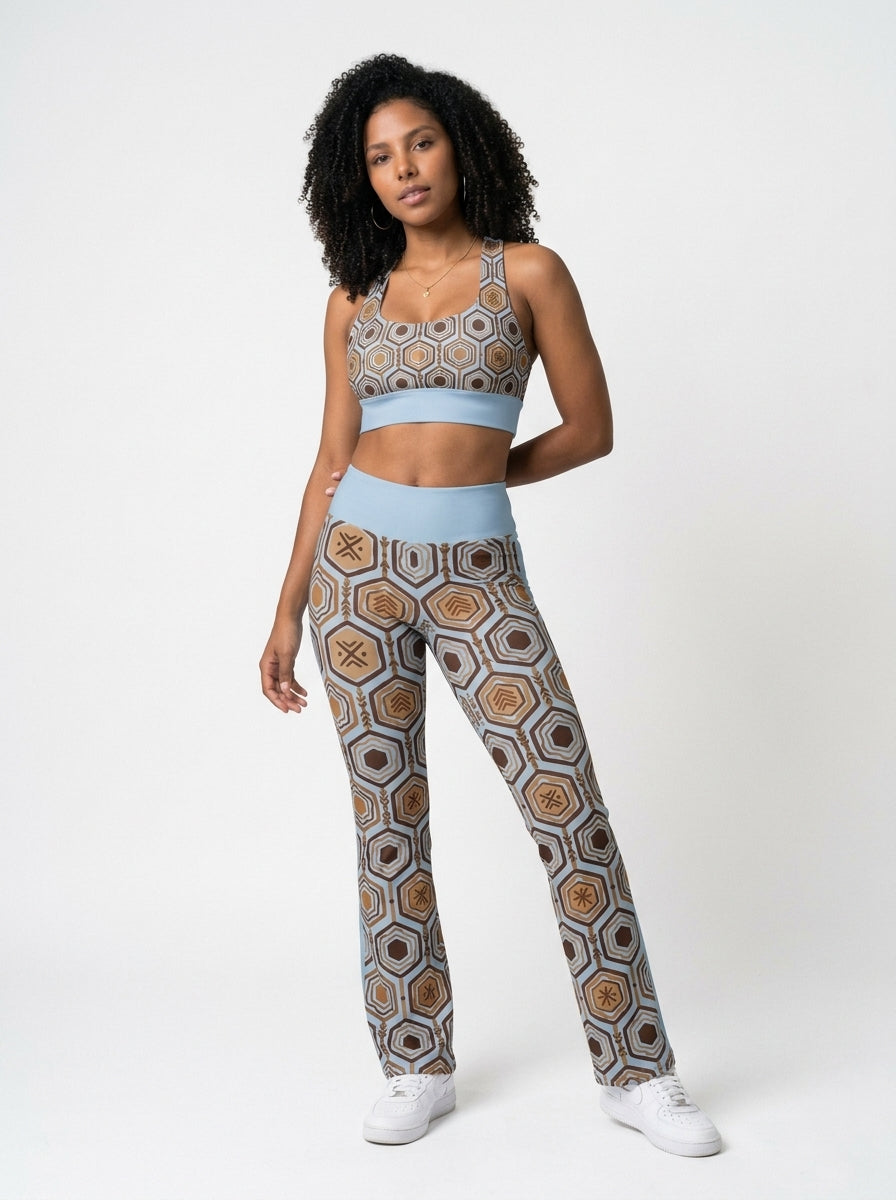 Woman wearing the Igwe Blue AnanseNova™ Set — Longline Sports Bra and Flare Leggings in matching hexagon print, front view