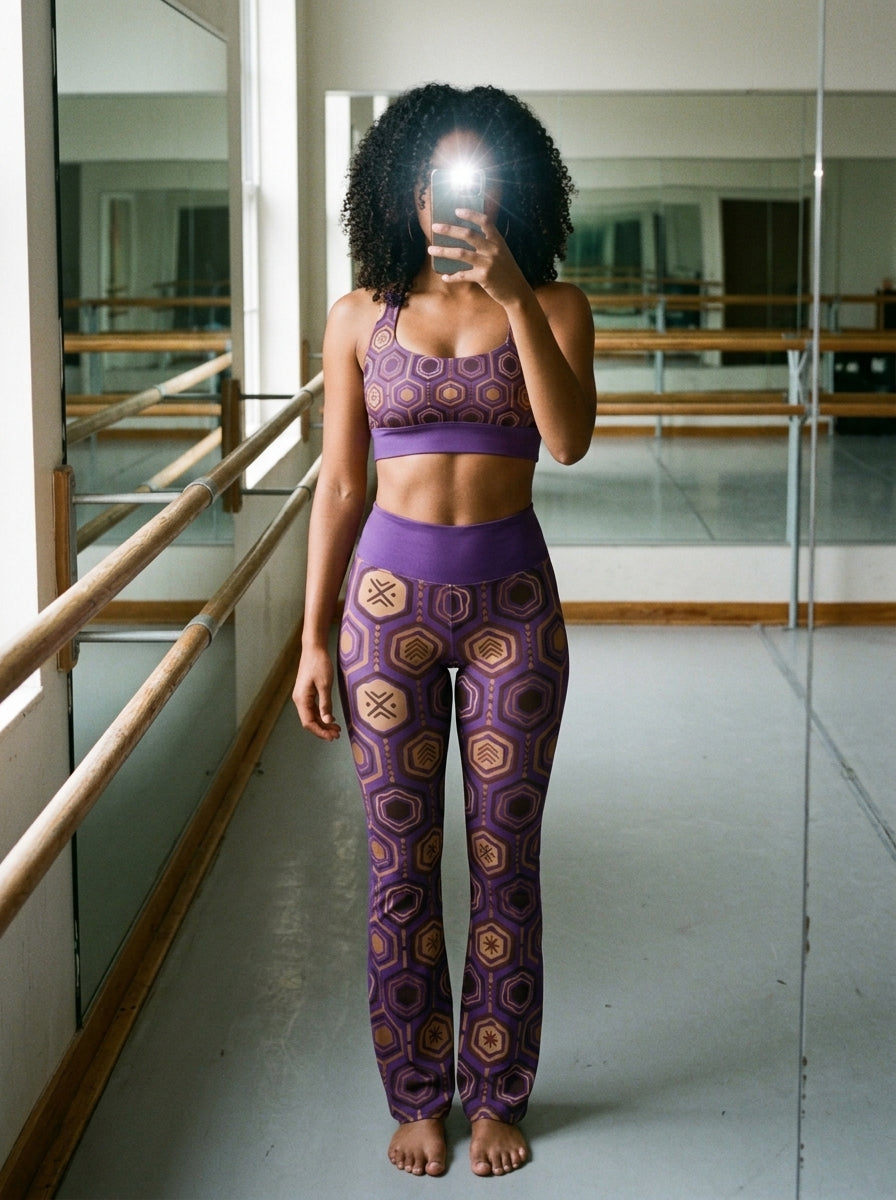 Pilates studio selfie in the Ugo Purple AnanseNova™ Set — hexagon-print longline sports bra and flare leggings