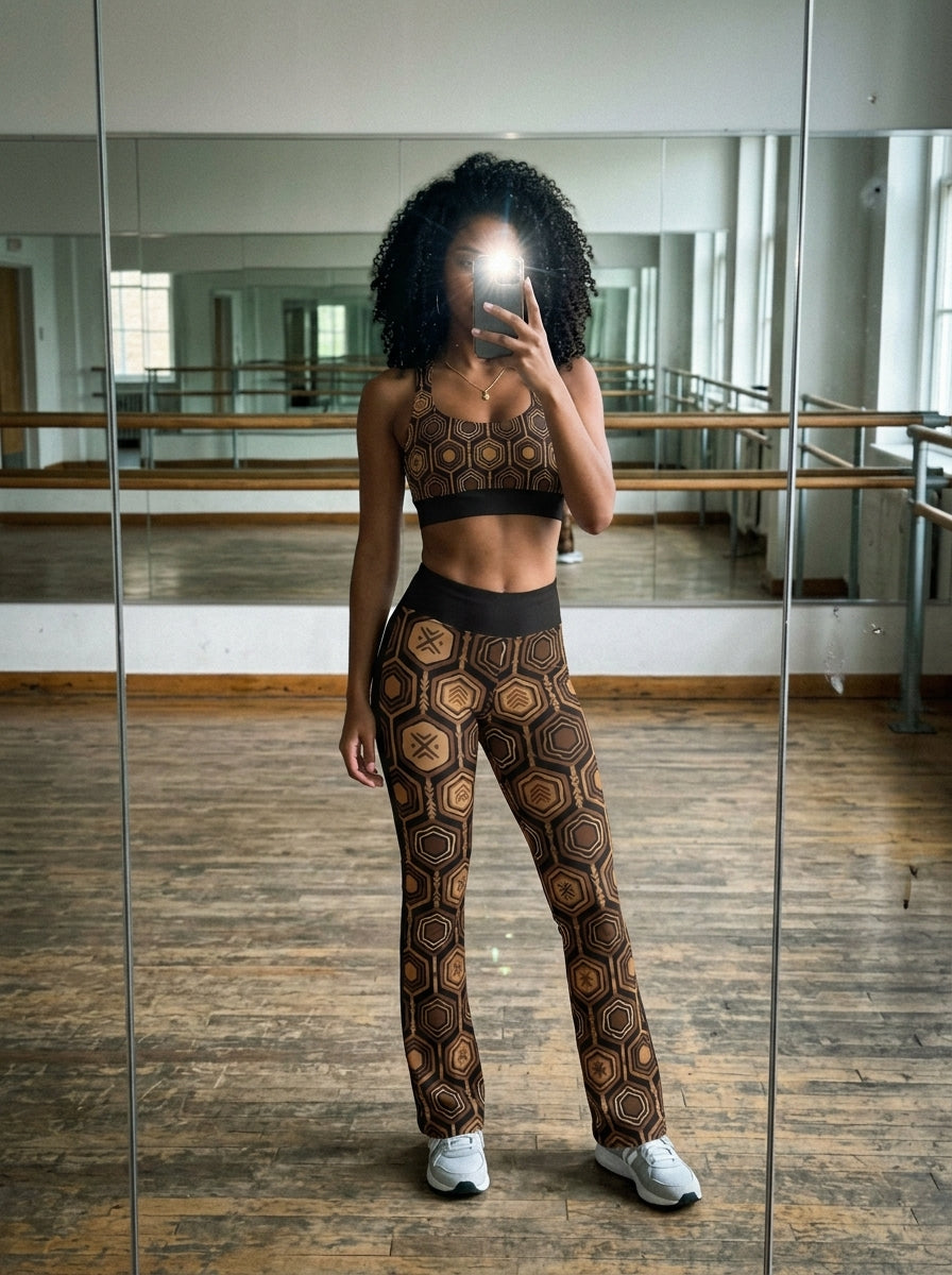 Pilates studio selfie in the Oji Black AnanseNova™ Set — hexagon-print longline sports bra and flare leggings