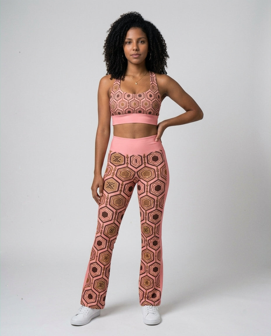 Woman wearing the Adaeze Pink AnanseNova™ Set — Longline Sports Bra and Flare Leggings in matching hexagon print, front view