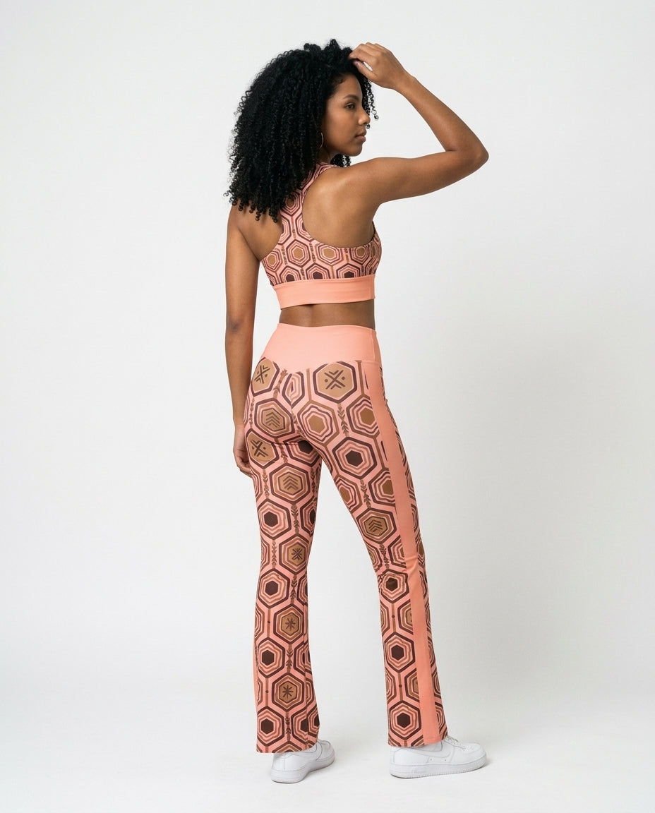 Back view of the Adaeze Pink AnanseNova™ Set — racerback longline sports bra and high-waisted flare leggings in hexagon print