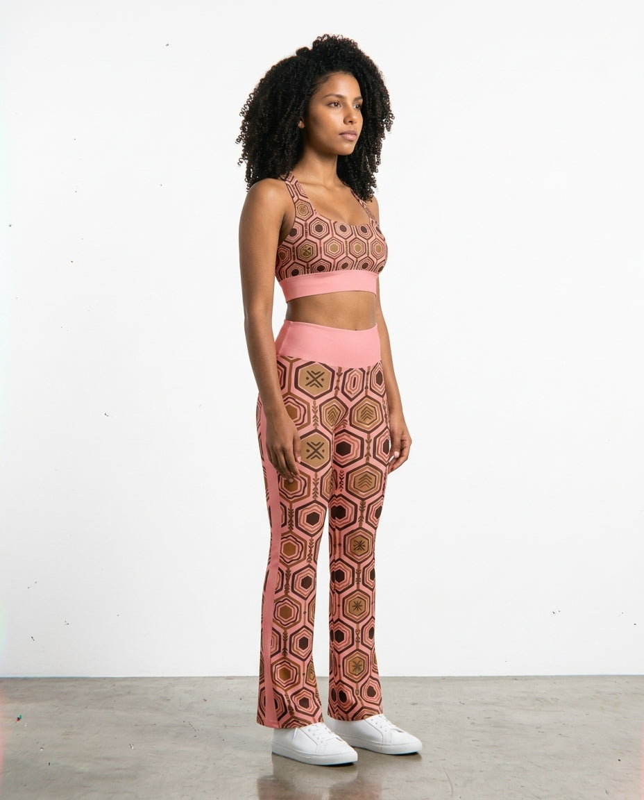 Three-quarter right view of the Adaeze Pink AnanseNova™ Set, hexagon-print longline sports bra and flare leggings on AsaseFlex™ stretch