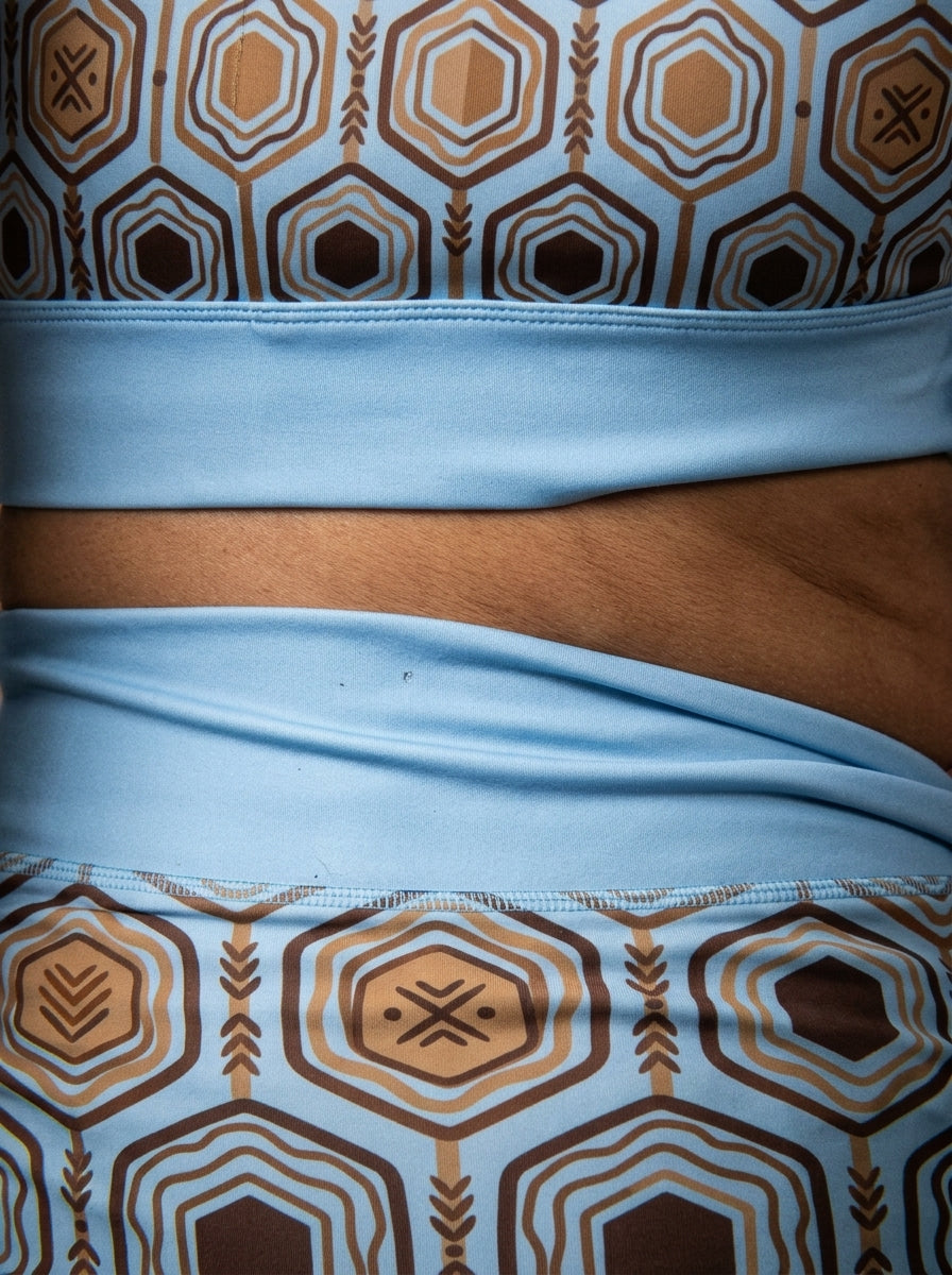 AnanseNova™ Set // Bra + Pocket Leggings in Igwe Blue — close-up detail of hexagon web-cell print, solid waistband, and side pocket seam on AsaseFlex™ stretch fabric