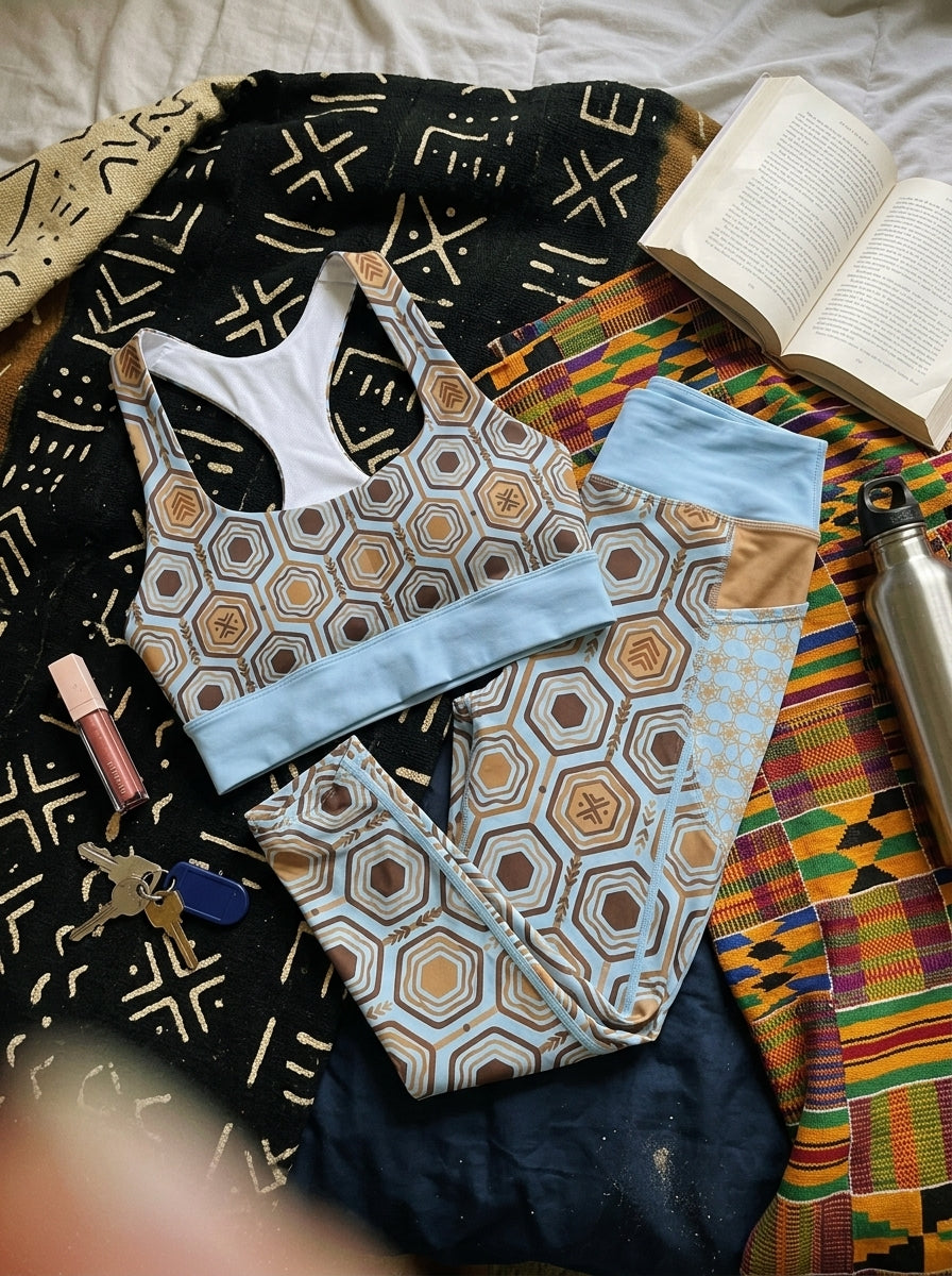 AnanseNova™ Set // Bra + Pocket Leggings in Igwe Blue — styled flat lay of the matching bra and pocket leggings with kente and mudcloth textiles