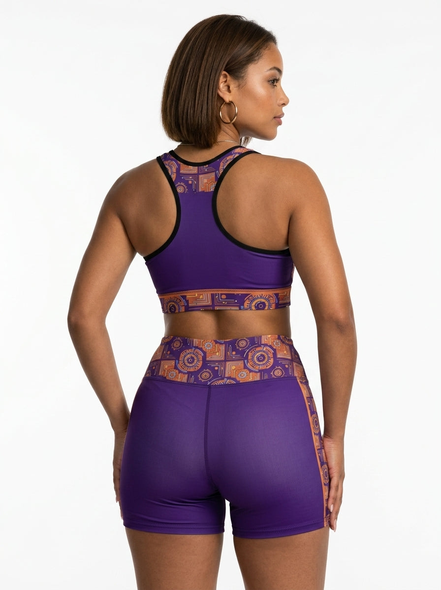 Sankofa bra and shorts set — outdoor candid shot on basketball court — Afrofuturist purple and orange print — SunBorn