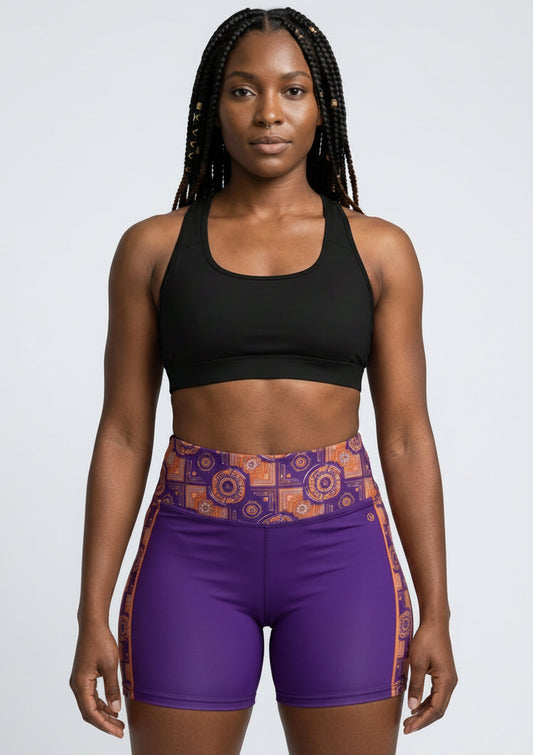 Sankofa Yoga Shorts in the purple, burnt orange and cyan Kinetic Engine print, studio front view — SunBorn