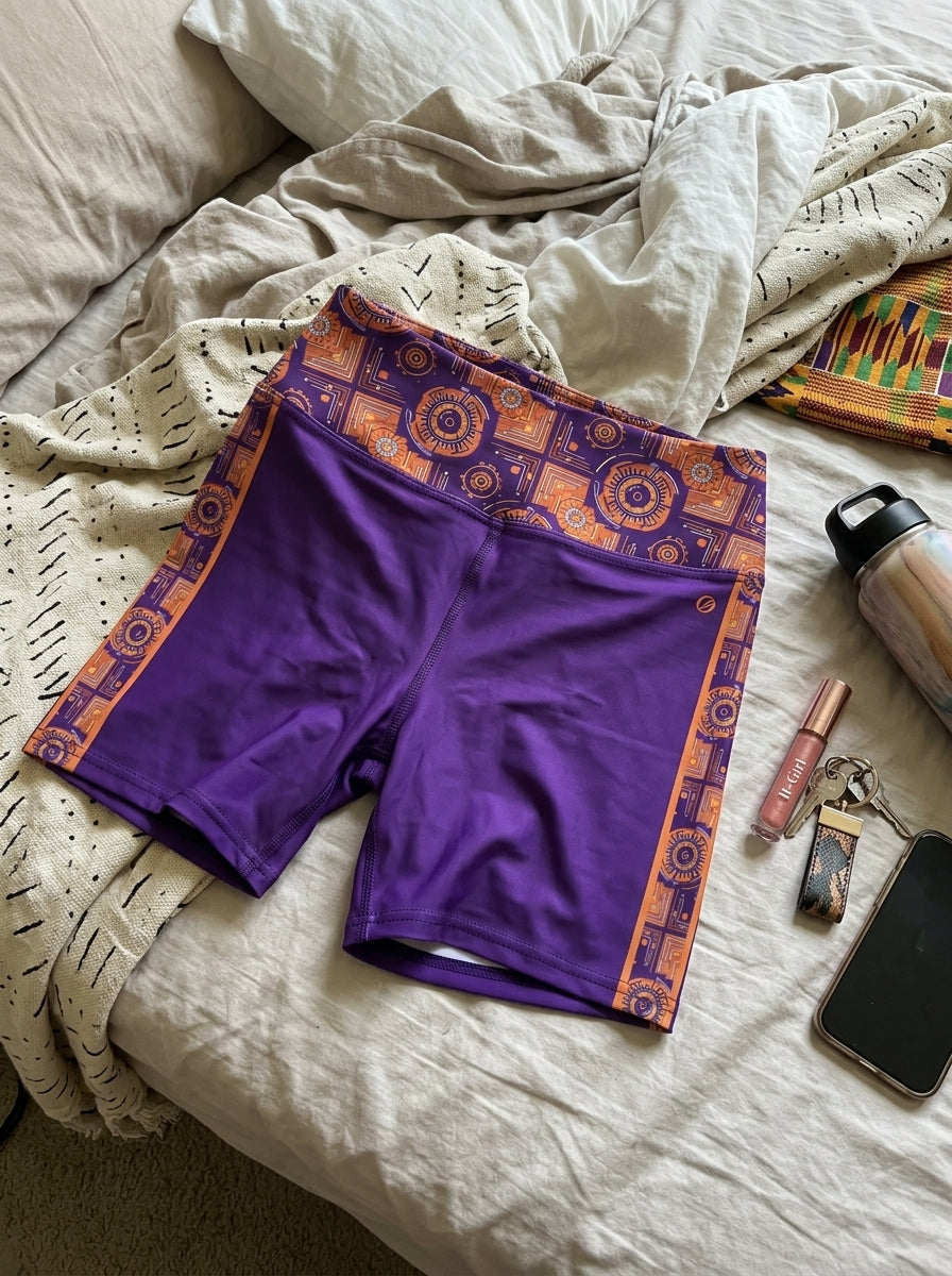 Sankofa Yoga Shorts in the Kinetic Engine print, flat lay with lifestyle accessories — SunBorn