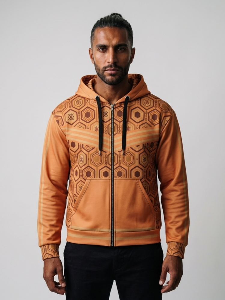 AnanseNova™ Zip Hoodie in Sango Orange, front view on model — hexagon all-over print, bronze chevron stripes, full zip