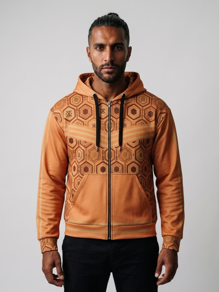 AnanseNova™ Zip Hoodie in Sango Orange, front view on model — hexagon all-over print, bronze chevron stripes, full zip